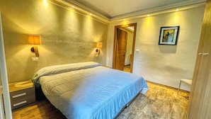 A bedroom with a bed, two wall-mounted lamps, a framed picture, and a mirror. - TABOR - APARTMENT sleeps 6 - 2nd floor (Bardonecchia)