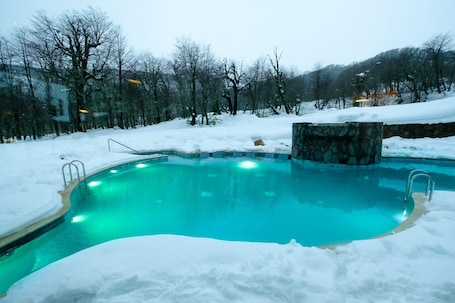 Una piscina techada, una piscina al aire libre de temporada, sombrillas. Hotel Termas Chillán