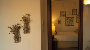 A room with a bed, a nightstand, and wall-mounted artwork.