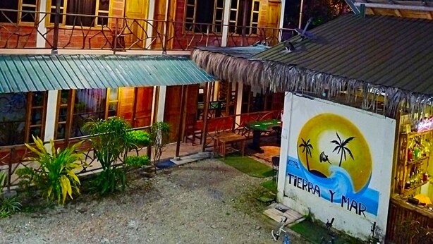 A two-story building with a balcony, a sign reading "TIERRA Y MAR", and bicycles parked in front. - Hostal Tierra y Mar (Manglaralto)