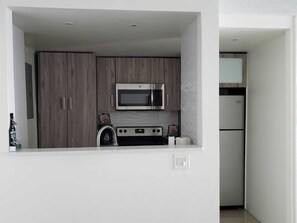 Enjoy cooking in this well-equipped kitchen with an oven, microwave, and refrigerator.