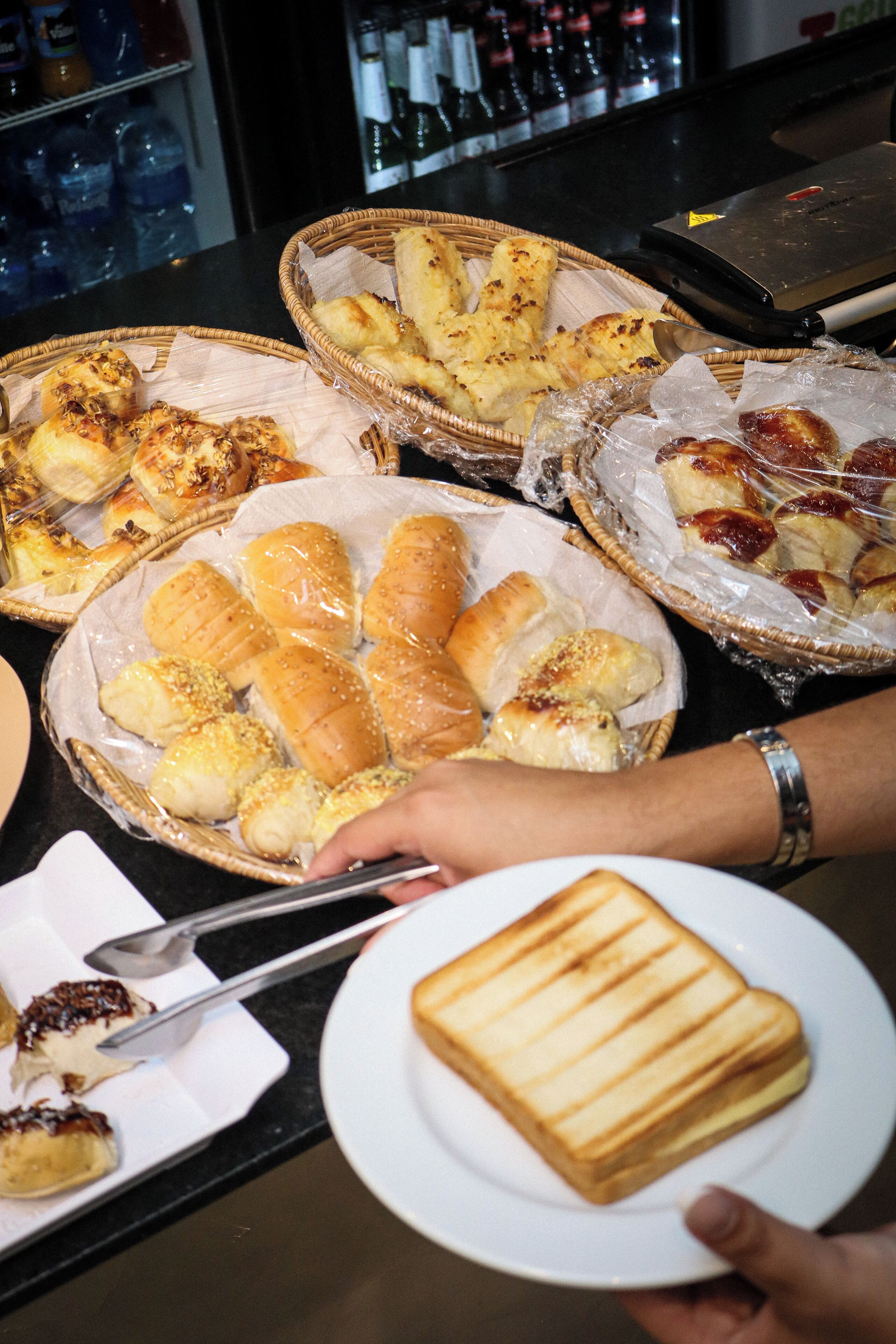 En buffet med forskelligt brød og en tallerken med en panini.