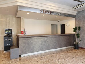 A reception desk labeled 'FRONT' with a digital kiosk, a clock, and a potted plant. - Tabist Hotel New Osamura Sabae Inter (Sabae)
