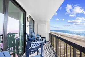 A balcony with a view of the beach and ocean.
