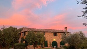 A stone building with a tiled roof, surrounded by greenery and a well-maintained lawn. - Delightful secluded Tuscan farmhouse with pool, near the hilltop town of Cetona. (Cetona, SI)