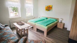 A room with a bed, a table, a chair, and a radiator. - Haus Sonnenwalde - Familie Ruhe (Rohrbach)