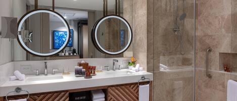 Un baño moderno con dos espejos grandes, ducha y tocador con diseño de paneles de madera.