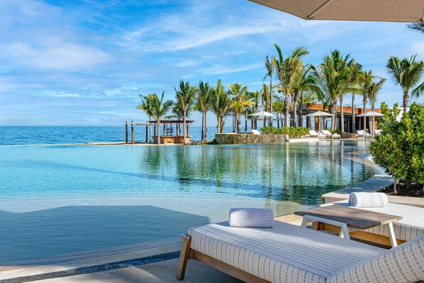 A poolside area with lounge chairs and a view of the ocean. - Conrad Punta de Mita (Punta de Mita)