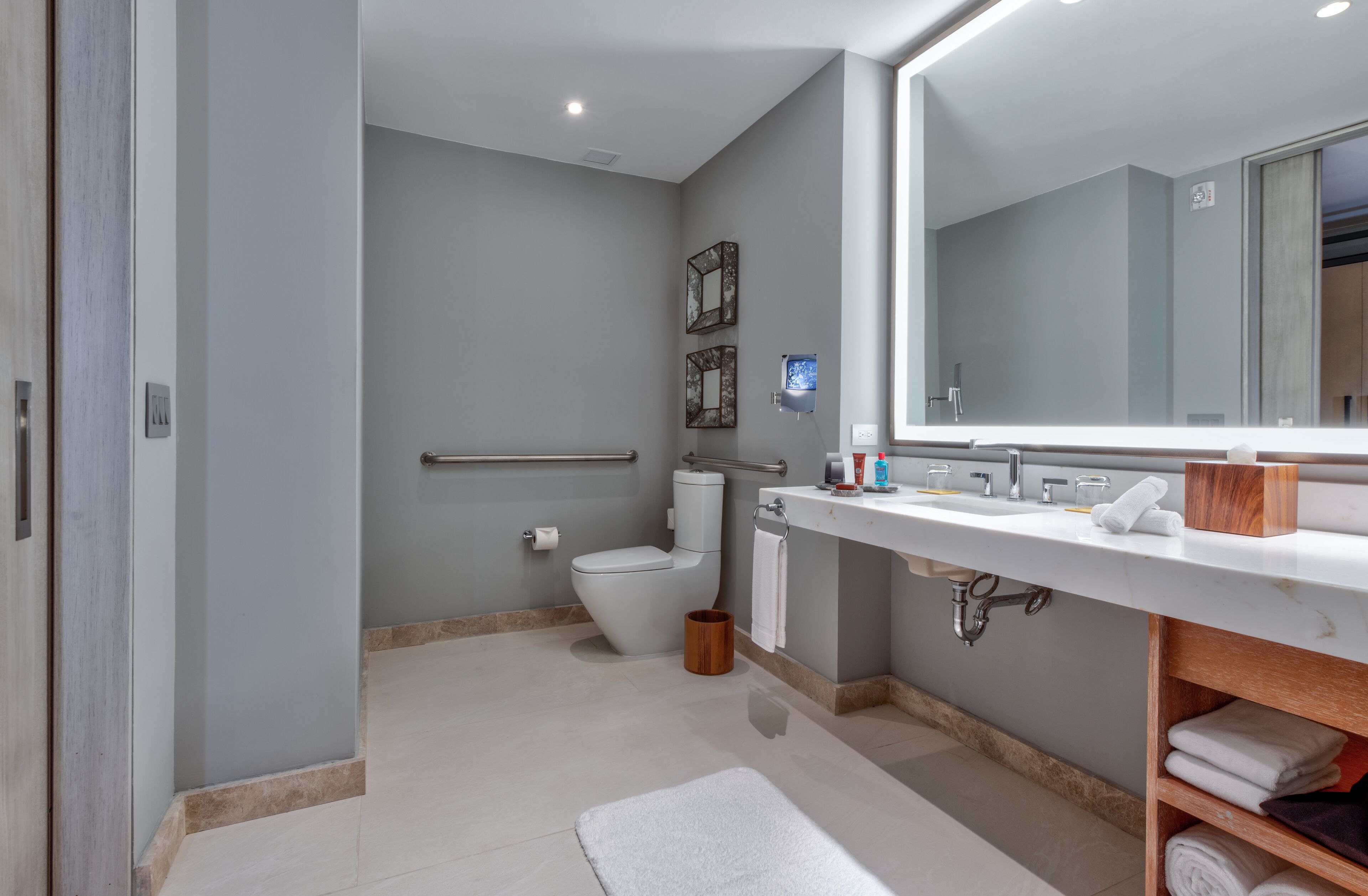 Een moderne badkamer met toilet, wastafel en spiegel.
