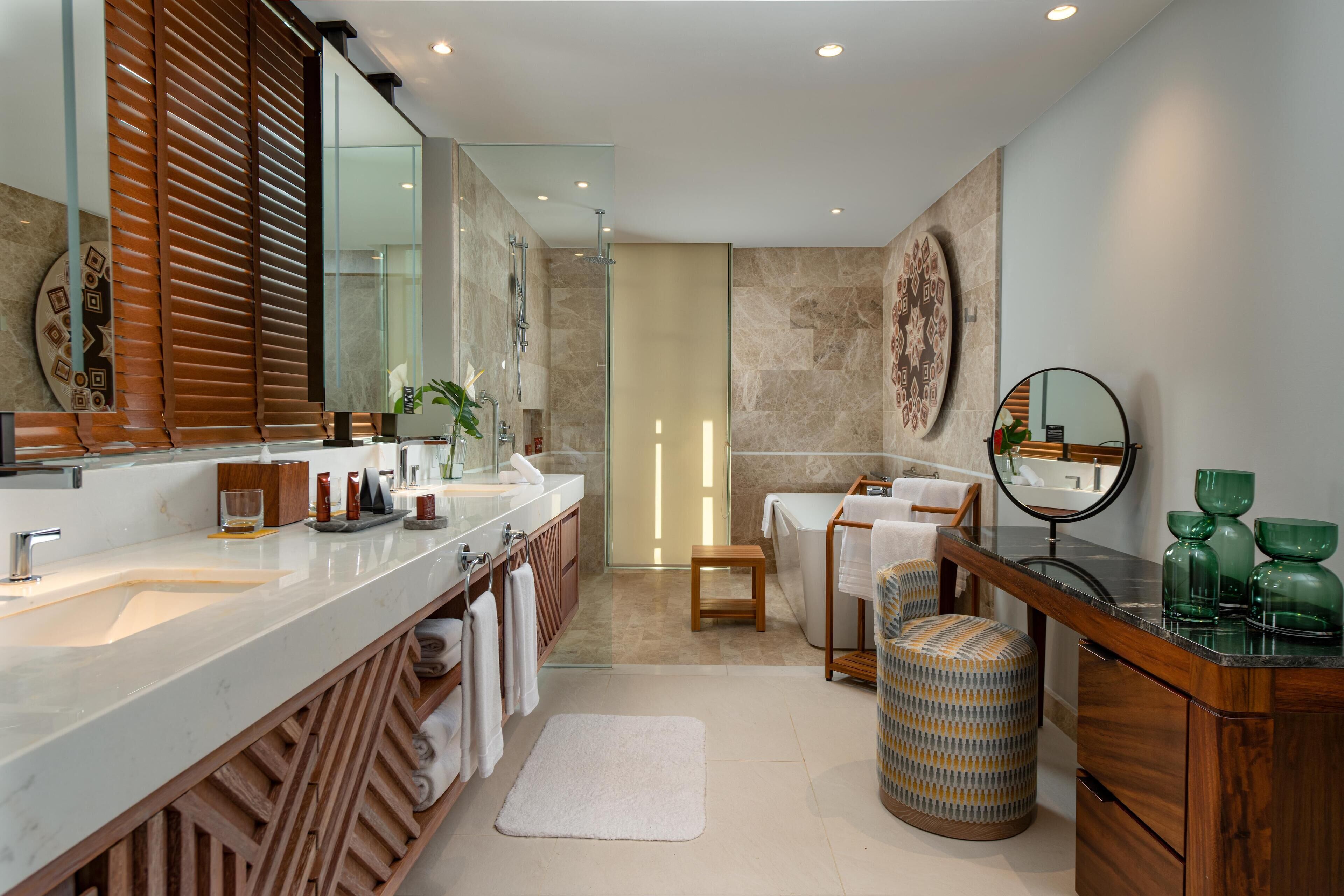 Un bagno moderno con un ampio specchio, due lavabi, una doccia e un mobile vanità con specchio.