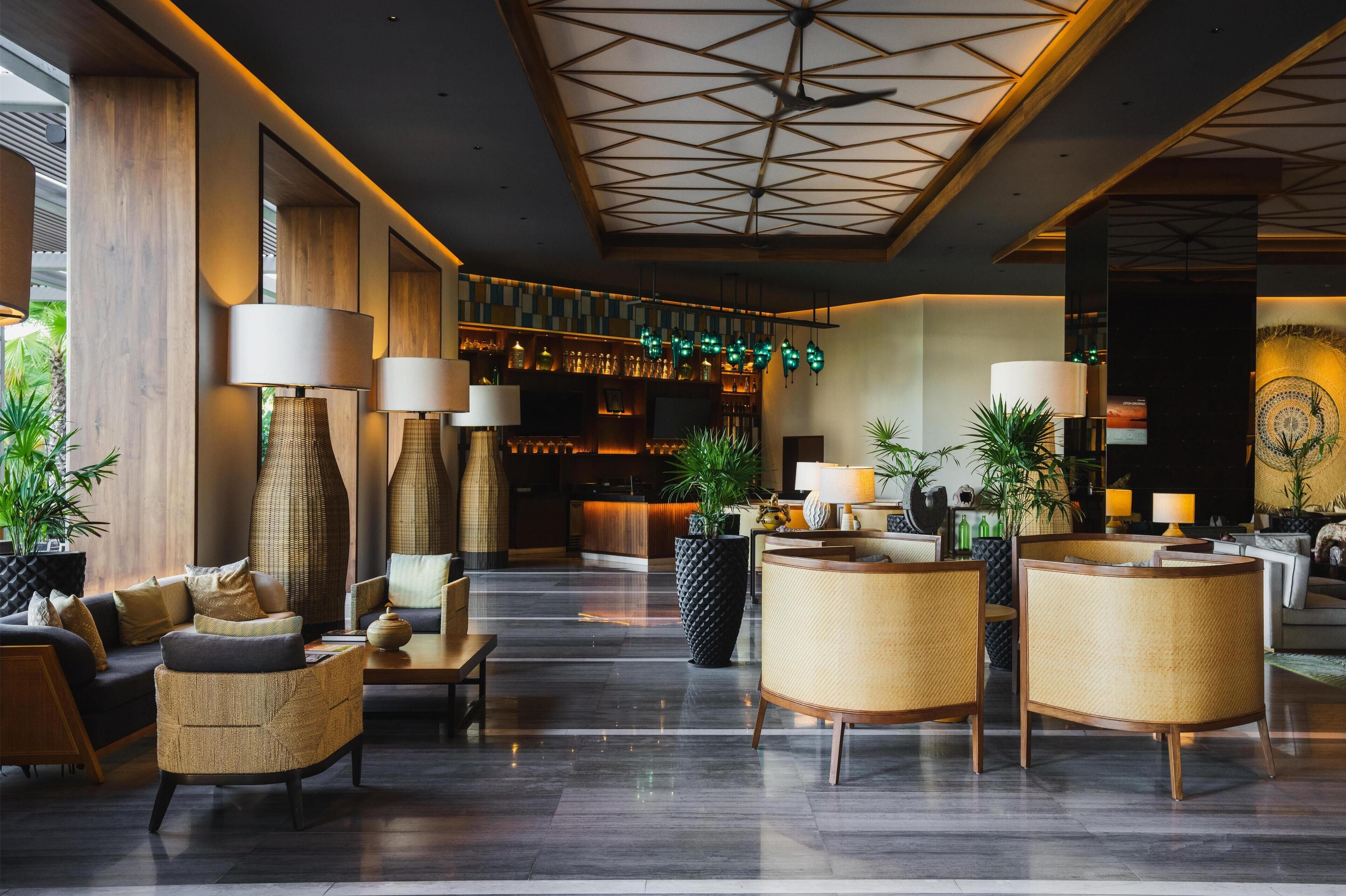 A spacious lobby with a reception desk, seating area, and a bar.