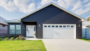 A modern two-story house with a dark exterior, a white garage door, and a front entrance with a door number 1712.