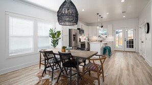 A modern kitchen with white cabinets, stainless steel appliances, and a central island.