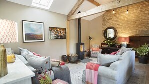 Una sala de estar acogedora con chimenea, un sofá, una mesa de centro y una estantería.
