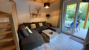 A modern living room with a sectional sofa, a coffee table, and a painting of a deer.