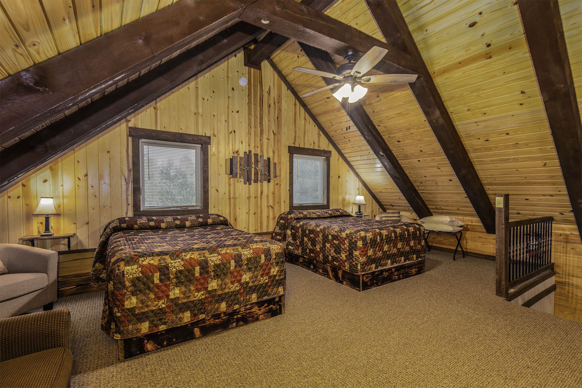 Une chambre mansardée chaleureuse, avec deux lits, des poutres en bois et un plafond en pente.