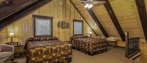 Une chambre mansardée chaleureuse, avec deux lits, des poutres en bois et un plafond en pente.