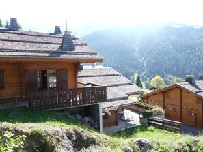 Eine Holzhütte mit Balkon mit Blick auf eine Berglandschaft.