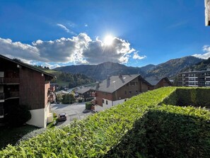 A residential area with houses, a parking lot, and a mountain in the background.