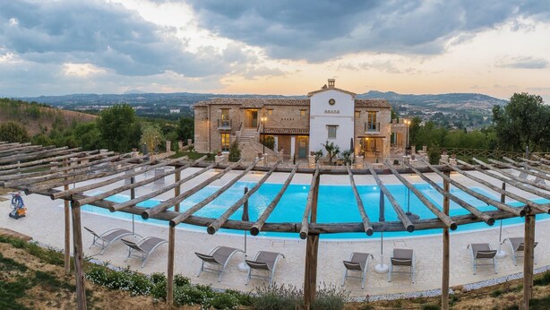 A poolside area with a pool, wooden pergolas, and lounge chairs. - Villa Sant'Angelo (Alba Adriatica)