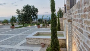 A courtyard with stone flooring, a rectangular water feature, and a tall, narrow tree. - Villa Sant'Angelo (Alba Adriatica)