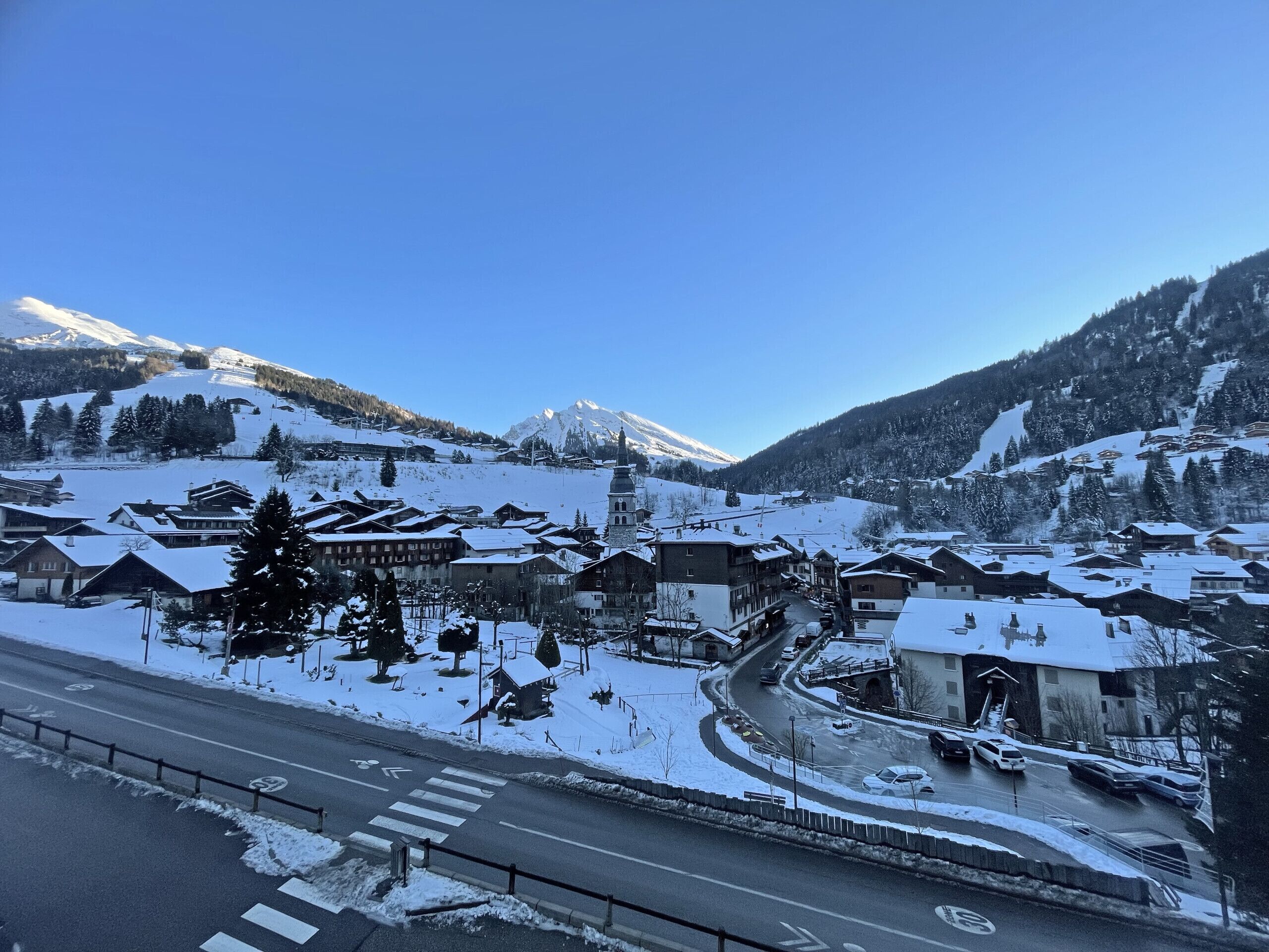 Un pueblo cubierto de nieve con edificios tradicionales y un cielo azul despejado.