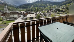 Un balcone con vista su un villaggio, una chiesa e montagne.