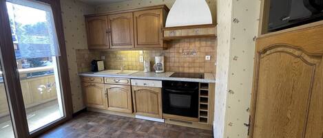 A kitchen with wooden cabinets, a built-in oven, and a microwave.