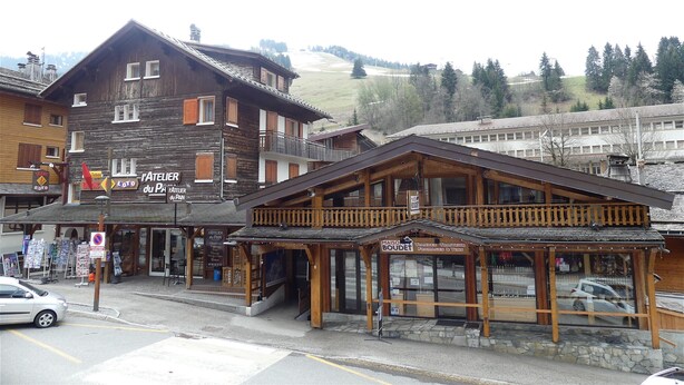 Un edificio in legno con un'insegna per una panetteria e un negozio di vino.