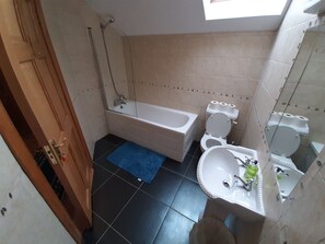 Een douche, handdoeken, zeep, toiletpapier