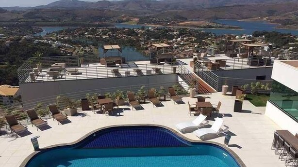 A rooftop pool with lounge chairs and a view of a lake and mountains. - Casa no Mirante de Escarpas (Capitólio)