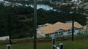 A view from a high vantage point overlooking a town with a river, buildings, and hills in the distance. - Casa no Mirante de Escarpas (Capitólio)