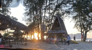 A beachside setting with thatched-roof huts, bicycles, and a water tank. - Blue Lagoon Home Trang (Kantang)