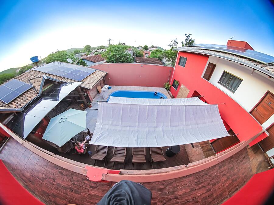 Una azotea con paneles solares, piscina y una zona de estar cubierta.