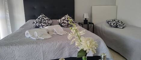 Habitación triple | Decoración personalizada y espacio para trabajar con laptop