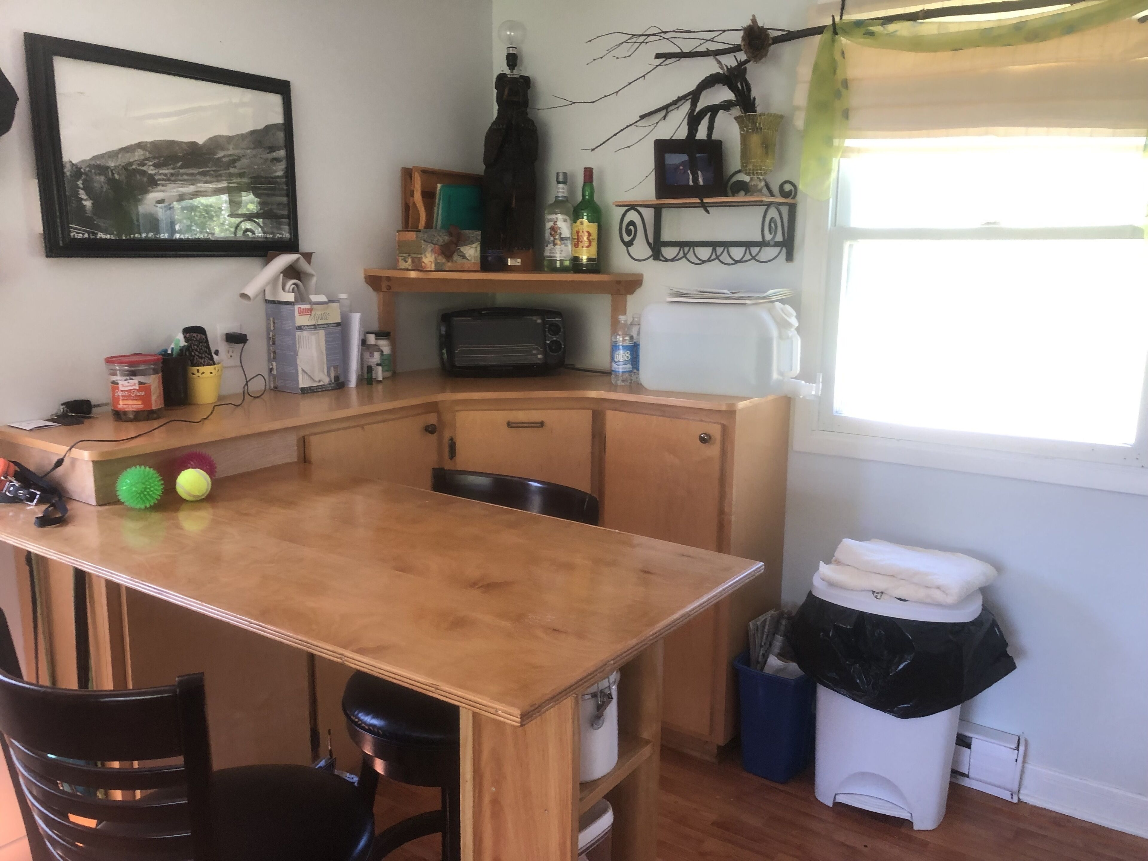 A compact kitchen with a wooden countertop, a toaster, a sink, and a window with a view of the outdoors.