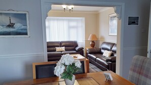 Een woonkamer met een houten salontafel, een bank en een lamp.