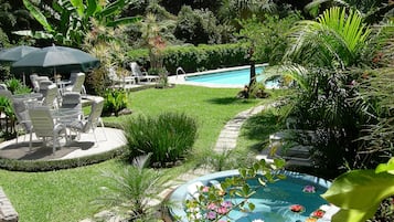 A backyard with a swimming pool, a hot tub, and outdoor furniture.