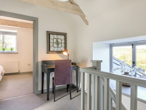 A room with a desk, chair, and a large window.