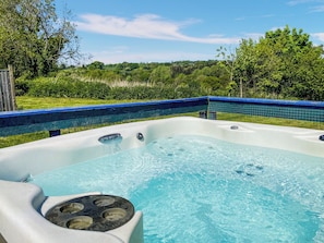 A hot tub with a view of a lush green landscape.