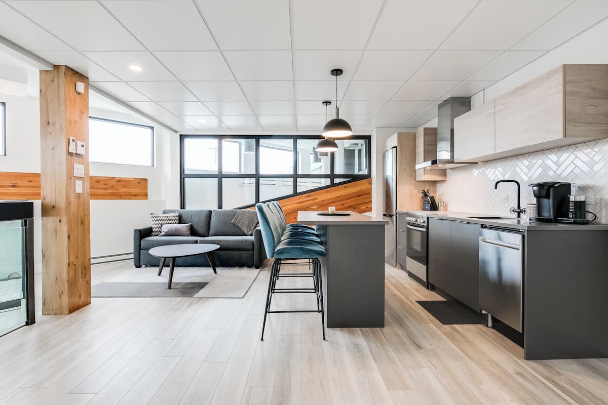 A modern kitchen with a central island, built-in appliances, and a large window providing natural light.