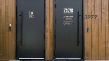 Due porte nere con pannelli di legno, una con il numero 202 e l'altra con il 3977.