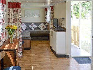A cozy living room with a sofa, a coffee table, and a TV on a stand. - 2 bedroom accommodation in Stalham (Stalham)