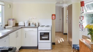A compact kitchen with a stove, oven, and modern appliances.