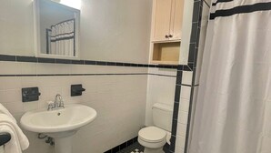 Un baño con lavamanos blanco, inodoro y cortina de ducha.