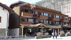Un bâtiment en bois doté de plusieurs balcons, une devanture portant l’inscription « Sport 2000 » et une enseigne « Zig Zag ».