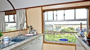 Una cucina con vista su un binario ferroviario e sulla vegetazione.