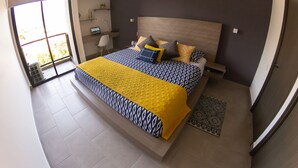 Une chambre à coucher avec un lit, des tables de chevet, un bureau, une chaise et une fenêtre.