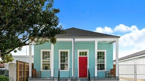 A two-story house with a red door, white trim, and a blue exterior. - 15% OFF Monthly | 10% OFF Weekly-Spacious 5BR Near Magazine St & Uptown (New Orleans)