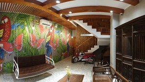 Ein Wohnzimmer mit Wandgemälde, einer Couch, einem Couchtisch und einer Treppe.